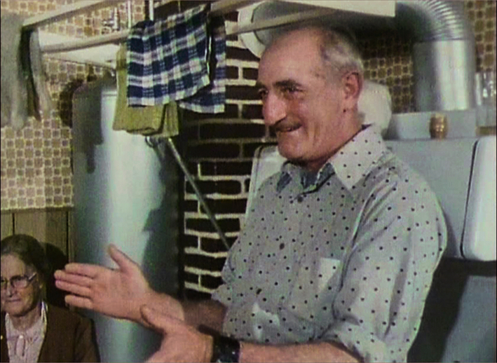 Dermot Roche watching a dance in his kitchen, August 1980 / The Radharc Trust Film Archive